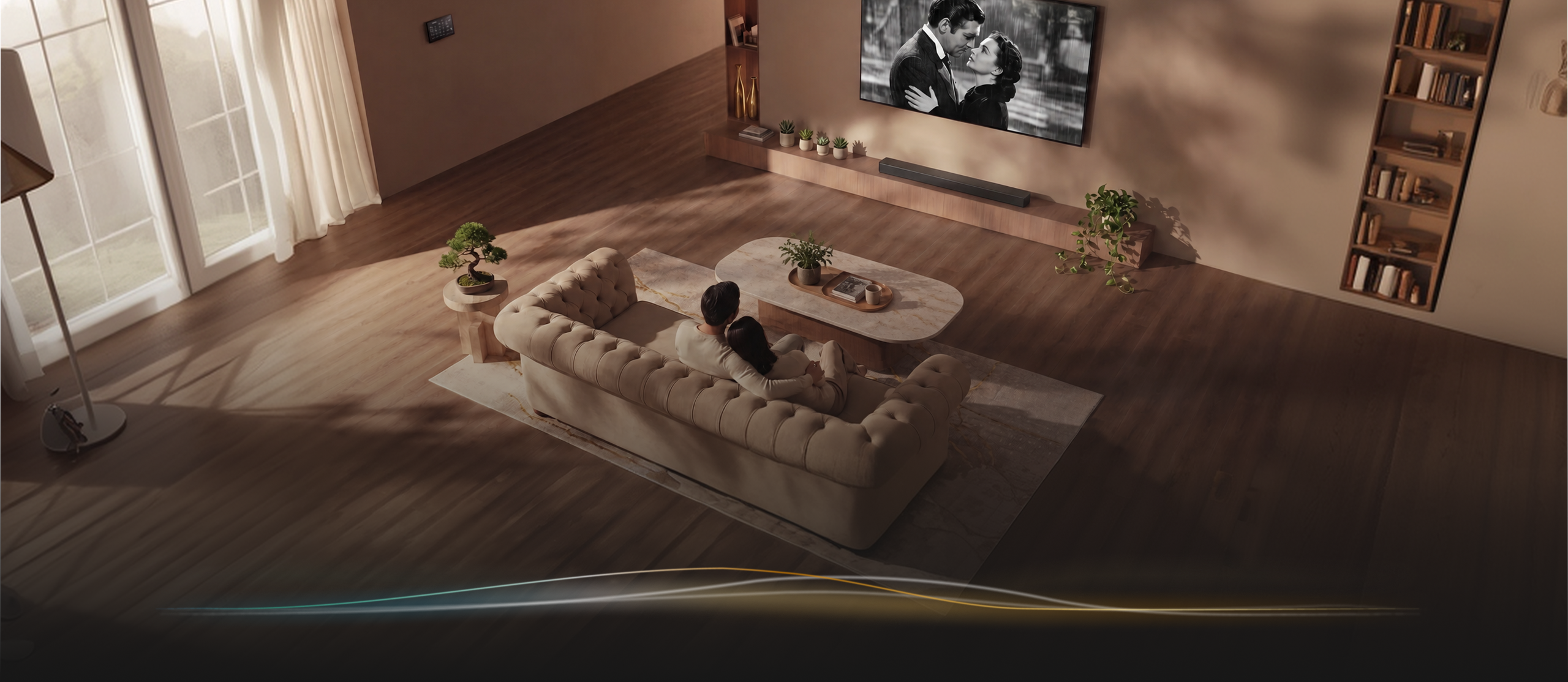 A couple sitting close on a sofa watching a classic film on a wall-mounted TV in a warm living room
